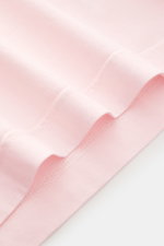 Nahaufnahme der Saumnaht des 04651/ A trip in a bag Rundhals-T-Shirt rosé, Jersey aus reiner Baumwolle, weicher Griff, Regular Fit, Rundhalsausschnitt, kleines Weblabel.