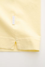 Nahaufnahme des Saumabschnitts vom 04651/ A trip in a bag Rundhals-T-Shirt pastellgelb, Jersey aus reiner Baumwolle, weicher Griff, Regular Fit, Rundhalsausschnitt, kleines Weblabel sichtbar.