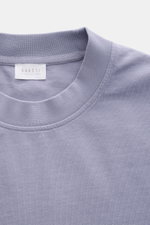 Nahaufnahme des lavenderfarbenen 04651/ A trip in a bag Rundhals-T-Shirts aus schwerem Baumwoll-Jersey mit kleinem Weblabel.