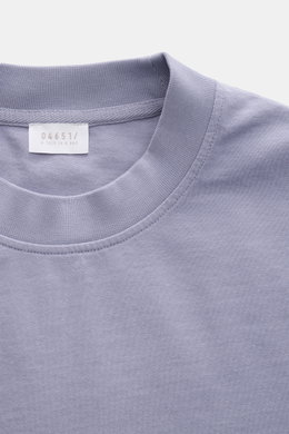 Nahaufnahme des lavenderfarbenen 04651/ A trip in a bag Rundhals-T-Shirts aus schwerem Baumwoll-Jersey mit kleinem Weblabel.