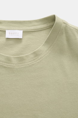 Close-up front view of the 04651/ A trip in a bag Piqué T-shirt sage, showing crew neck and woven label inside.

<p>Summer essential: This piqué T-shirt from 04651/ A TRIP IN A BAG is a versatile staple that's perfect for warm days.</p>
<ul>
<li>Pure piqu