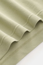 Close-up front view of the 04651/ A trip in a bag Piqué T-shirt sage showing pure piqué cotton fabric with ribbed bands and stitching detail.

<p>Summer essential: This piqué T-shirt from 04651/ A TRIP IN A BAG is a versatile staple that's perfect for war
