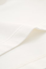 04651/ A trip in a bag Rundhals-T-Shirt 'If Tee' creme, Nahaufnahme der elastischen Baumwoll-Jersey Qualität mit weichem Griff und Nähten aus Oversized Fit, Weblabel seitlich sichtbar.