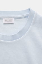 Frontnahes Detailfoto des pastellblauen 04651/ A trip in a bag Piqué-T-Shirts 'TP' mit Rundhalsausschnitt, Weblabel und Rippbündchen.