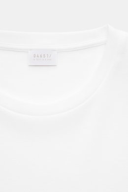 Close-up front view of the neckline and label of the 04651/ A trip in a bag Piqué-T-Shirt 'TP' weiß in white cotton piqué fabric.

<p>Summer Essential: Das Piqué-T-Shirt von 04651/ A TRIP IN A BAG überzeugt an warmen Tagen als vielseitiges Basic.</p>
<ul>