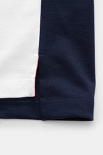 Nahaufnahme des Thom Browne T-shirt weiß/schwarz, von unten fotografiert, zeigt reine Baumwolle, weichen Griff, slim fit, Rundhalsausschnitt, Brusttasche, kontrastfarbene Streifen am Arm, kurze Saumschlitze, verlängerte Rückseite.