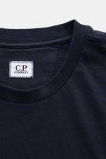Nahaufnahme des C.P. Company Rundhals-T-Shirts dark navy von oben, Jersey aus Baumwolle, weicher Griff, Slim Fit, Rundhalsausschnitt, Logo-Patch auf der Brust.