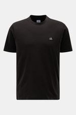 C.P. Company Rundhals-T-Shirt schwarz, vorne nah aus direkter Perspektive fotografiert, mit weichem Griff, Slim Fit, Logo-Patch auf der Brust, aus reiner Baumwolle.