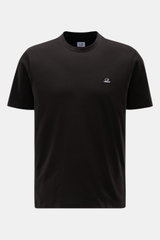 C.P. Company Rundhals-T-Shirt schwarz, vorne nah aus direkter Perspektive fotografiert, mit weichem Griff, Slim Fit, Logo-Patch auf der Brust, aus reiner Baumwolle.