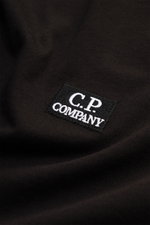 Nahaufnahme des schwarzen C.P. Company Rundhals-T-Shirts mit Logo-Patch auf der Brust, weicher Baumwoll-Jersey, Slim Fit, Frontansicht.