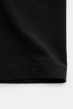 Nahaufnahme des Stone Island Rundhals-T-Shirts 'Ghost Piece' schwarz aus geschmeidigem Baumwolljersey, Slim Fit, mit tonalem Weblabel, perspektivisch von der Seite fotografiert.