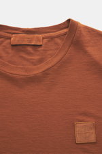 Close-up front view of Stone Island Crew Neck T-Shirt 'Ghost Piece' rust brown showing crew neckline and tonal woven label.

<p>With this crew neck T-shirt made of smooth cotton jersey, featuring a tonal woven label on the chest, STONE ISLAND offers a com