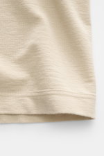 Close-up of beige cotton jersey fabric of Stone Island Crew Neck T-Shirt 'Ghost Piece' showing texture and hem from a side angle.

Description:
<p>With the crew neck T-shirt made of smooth cotton jersey, featuring a tonal woven label on the chest, STONE I