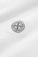 Close-up, top-down view of the Stone Island Rundhals-T-Shirt 'Organic Cotton' offwhite showing the iconic chest web label on soft, pure organic cotton fabric.

<p>Zeitlos, vielseitig und nachhaltig: Das T-Shirt von <span class="hover:entity-accent entity-