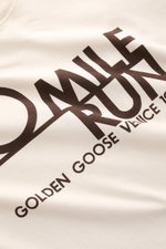 Golden Goose Crew Neck T-Shirt Cream shown in a close-up front angled view, featuring bold dark lettering on cream pure cotton fabric.