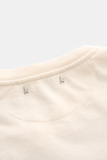 Golden Goose Crew Neck T-Shirt Cream viewed close-up from the top, showing the ribbed crew neckline, cream pure cotton fabric, and small metal star studs. A bold statement for warm days: The T-shirt by GOLDEN GOOSE stands out with a striking print and its
