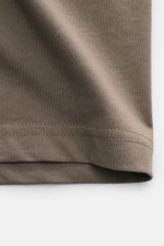 Belstaff Rundhals-T-Shirt taupe aus weichem Baumwoll-Jersey in Slim Fit, Nahaufnahme der Stoffstruktur und Saum von schräger Perspektive.