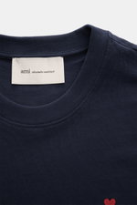 Ami Paris Crew Neck T-Shirt Navy shown from a top front close-up, featuring pure cotton jersey, soft feel, slim fit, crew neckline, red heart stitching on chest, and tonal AMI stitching on back. Classic jersey basic from the French label AMI PARIS: This c