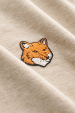 Maison Kitsuné Crew Neck T-Shirt 'Fox Head' beige melange shown close-up from above, highlighting the typical fox patch on soft cotton jersey.