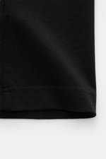 Close-up shot from the front of the Jacquemus Crew Neck T-Shirt Black, showing pure cotton fabric, soft touch, slim fit, and grosgrain with logo stitching on the chest.