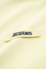 Close-up shot of Jacquemus Crew Neck T-Shirt light yellow showing pure cotton fabric with a soft touch, slim fit, and a Grosgrain strip with logo stitching on the chest.