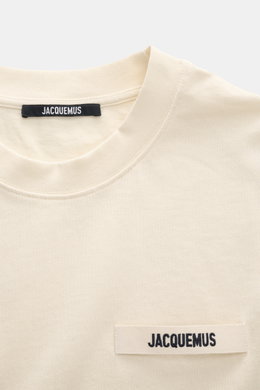 Jacquemus Crew Neck T-Shirt cream shown from a close-up front perspective, pure cotton, soft touch, slim fit, grosgrain with logo stitching on chest.
