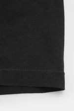 Close-up view of Jacquemus Crew neck T-Shirt black showing the fabric texture and hem stitching, pure cotton, soft touch, slim fit, logo print on the front.