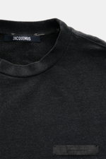 Nahaufnahme von Jacquemus Sweatshirt 'Ruban' dunkelgrau meliert mit Rundhalsausschnitt, Grosgrain-Logo-Stitching, Rippbündchen, Oversized Fit, schwerer Baumwolle, Ballonsaum.