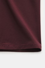 Close-up front view of burgundy fabric showing the texture of the Kiefermann Crew neck T-shirt 'Hero' burgundy, featuring a blend of cotton and modal, elasticated fabric, soft touch, slim fit, and crew neck.