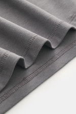 Close-up image of the dark grey fabric of the Kiefermann Crew neck T-shirt 'Hero' from a side perspective, showing fine stitching and soft texture; blend of cotton and modal, elasticated fabric, soft touch, slim fit, crew neck.