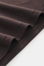Close-up image from a top-down perspective showing the dark brown fabric and stitching details of the Kiefermann Crew neck long sleeve 'Emil' dark brown, featuring jersey in modal and cotton, elasticated fabric, soft touch, slim fit, and crew neck.