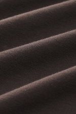 Close-up front view of fabric folds showing texture and detail of the Kiefermann Crew neck long sleeve 'Alberts' dark brown, jersey in modal and cotton, elasticated fabric, soft touch, slim fit, crew neck.