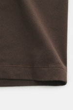 Officine Générale Crew Neck T-Shirt 'Cneck Tee' dark brown shown close-up from the front, highlighting pure organic cotton jersey fabric with a very soft touch, slim fit, and crew neckline. The soft feel of pure organic cotton makes the crew neck T-shirt 