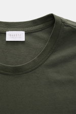 Close-up view from above of the neckline and label of the 04651/ A trip in a bag Crew neck T-Shirt 'Jersey Tee' grey green, a slim fit cotton jersey tee with soft feel and lightweight quality, featuring a crew neckline and woven label in the side seam.