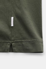 Close-up front view of the hem with woven label on the side seam of the 04651/ A trip in a bag Crew neck T-Shirt 'Jersey Tee' grey green.

<p>The uncomplicated cotton T-shirt 'Jersey Tee' by 04651/ A TRIP IN A BAG is an indispensable basic from the new se