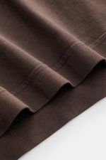 Close-up view of the folded sleeve hem of the 04651/ A trip in a bag Crew neck T-Shirt 'Jersey Tee' grey brown, showing soft cotton jersey fabric and fine stitching.

<p>The uncomplicated cotton T-shirt 'Jersey Tee' by 04651/ A TRIP IN A BAG is an indispe
