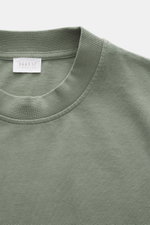 Close-up front view of 04651/ A trip in a bag Crew neck T-Shirt grey green showing crew neckline, small woven label, pure cotton, heavy quality, slightly textured feel, and regular fit. Durable basic for urban everyday life.
