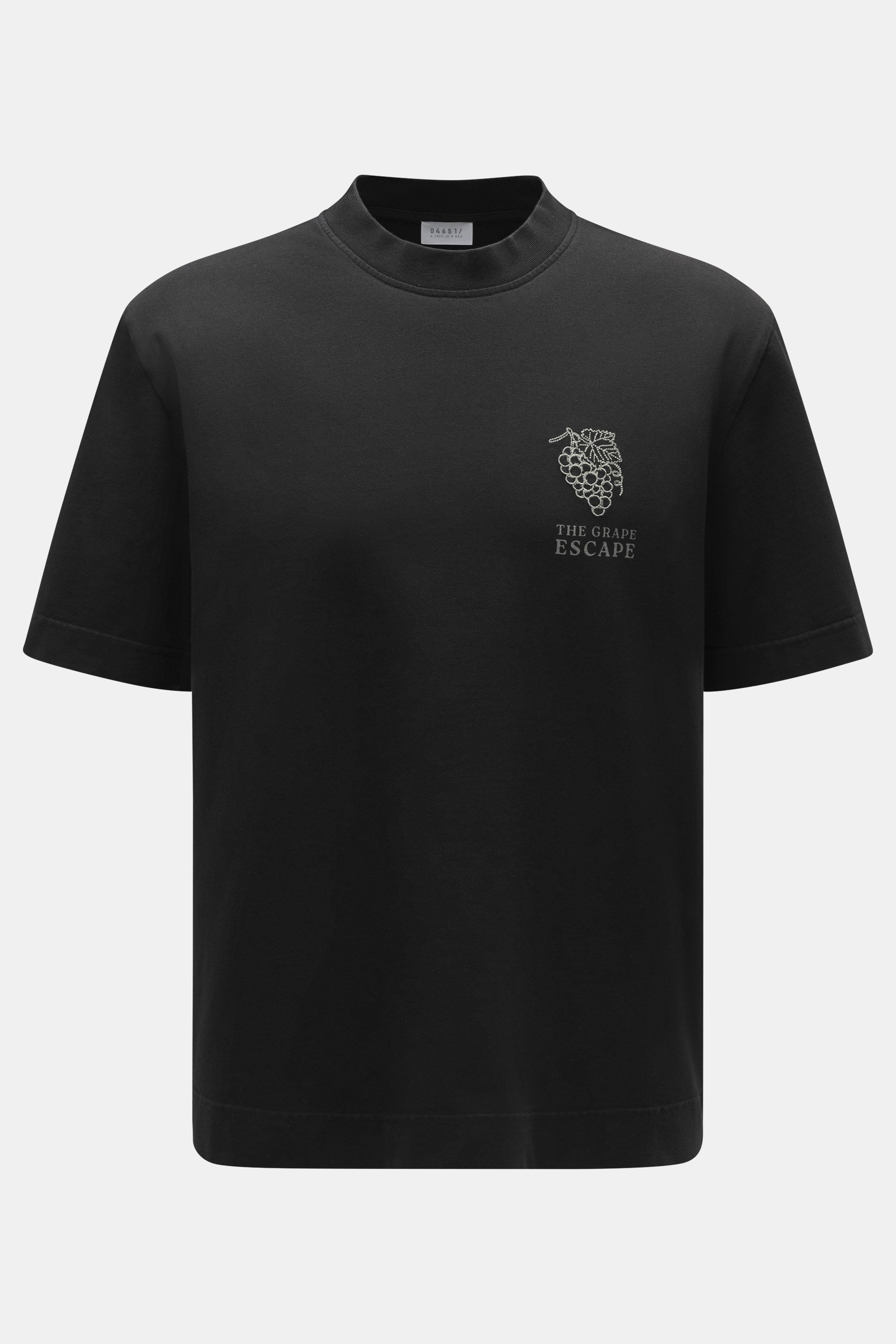 Front view of the 04651/ A trip in a bag Crew Neck T-Shirt 'Grape Escape' black, made of heavy cotton jersey with grape embroidery. Not just for wine lovers: The Crew Neck T-Shirt 'Grape Escape' by 04651/ A TRIP IN A BAG is made of heavy cotton jersey and
