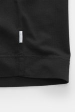 Schwarzer Ausschnitt des 04651/ A trip in a bag Rundhals-T-Shirt 'Grape Escape' aus schwerer Baumwolle mit kleinem Weblabel, Detailaufnahme.