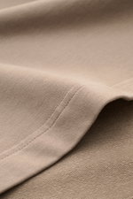 Nahaufnahme des taupefarbenen 04651/ A trip in a bag Rundhals-T-Shirts 'If Tee', elastischer Baumwolljersey mit weichem Griff, schwere Qualität, sichtbare Naht, Detail von der Seitennahtperspektive.