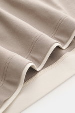 Close-up photograph from a top-down perspective of the hem and sleeves of the Brunello Cucinelli Crew neck T-shirt taupe/cream, showing soft cotton fabric and contrasting double hem stitching.

Description: <p>BRUNELLO CUCINELLI delivers an essential basi