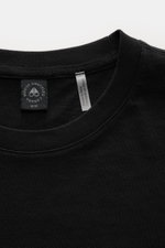 Close-up front view of Moose Knuckles Crew neck T-shirt 'Crescent Tee' black, showing collar and tags; jersey made of pure Pima cotton, soft feel, slim fit, crew neck, signature patch with metal logo on chest, rubberised label print on sleeve, small woven