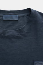 Stone Island Longsleeve 'Ghost Piece' graublau, Slim Fit Jersey aus Baumwolle, Rundhalsausschnitt, tonales Weblabel, Detailansicht von oben.
