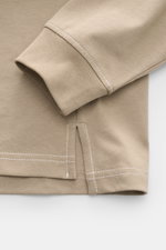 Nahaufnahme von Ärmel und Saum des Ami Paris Longsleeve taupe mit abgestepptem Herz-Logo, Jersey-Baumwolle, Oversized, Rundhalsausschnitt, rückwärtigem AMI-Stitching.