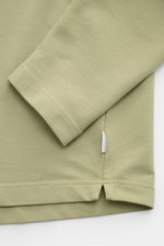 Close-up front view of 04651/ A trip in a bag Crew neck long sleeve 'If Tee' sage showing sleeve, hem, and woven label.

Description: <p>The uncomplicated long sleeve 'IF Tee' by 04651/ A TRIP IN A BAG is a core basic for the new season that give us a tas