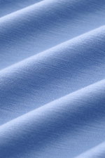 Nahaufnahme des elastischen, weichen Stoffes des 04651/ A trip in a bag Merino Longsleeve rauchblau aus Merinowolle, Detailfoto.