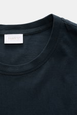 Close-up front view of the round neckline and label of the 04651/ A trip in a bag Longsleeve 'Jersey Tee' navy, made of soft, lightweight pure cotton jersey with a regular fit and short hem slits.