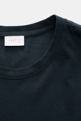 Close-up front view of the round neckline and label of the 04651/ A trip in a bag Longsleeve 'Jersey Tee' navy, made of soft, lightweight pure cotton jersey with a regular fit and short hem slits.