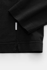 Close-up of the sleeve and hem of the 04651/ A trip in a bag Longsleeve 'Jersey Tee' black, showing fine stitching and label, photographed from above.

Description:  
<p>Versatile basic: The lightweight Longsleeve 'Jersey Tee' by 04651/ A TRIP IN A BAG is