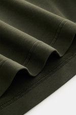 Nahaufnahme des graugrünen 04651/ A trip in a bag Longsleeve 'IF Tee' aus elastischem Baumwoll-Jersey mit weichem Griff, Rundhalsausschnitt und Saumschlitzen, fotografiert von oben.